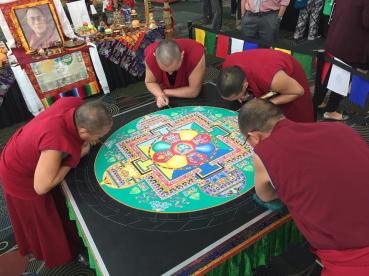 Tibet Monks from Daramsala creating a compassion mandala one grain of sand at a time.